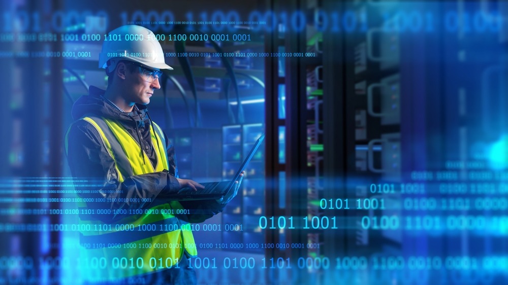 Worker in hard hat surrounded by digital binary data code