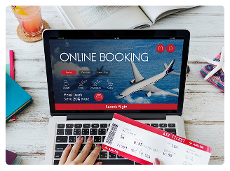 Top view of laptop displaying online booking portal alongside airline ticket