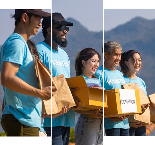 Volunteers smiling and holding donation boxes outdoors
