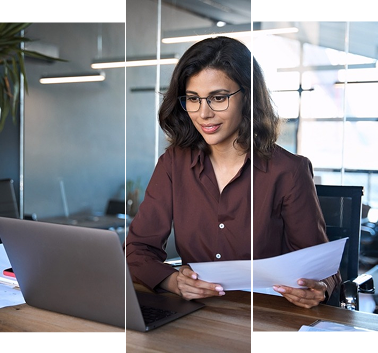 Government official working on laptop and reviewing paper documents